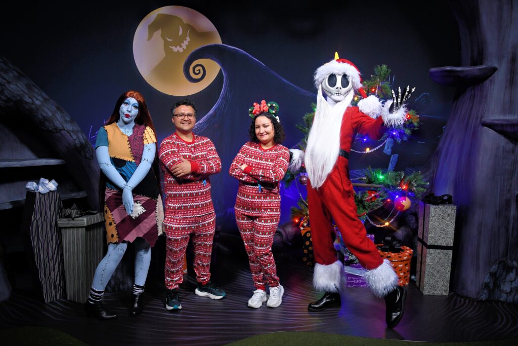 Familia disfrazada en Mickey's Very Merry Christmas Party frente al castillo de Magic Kingdom